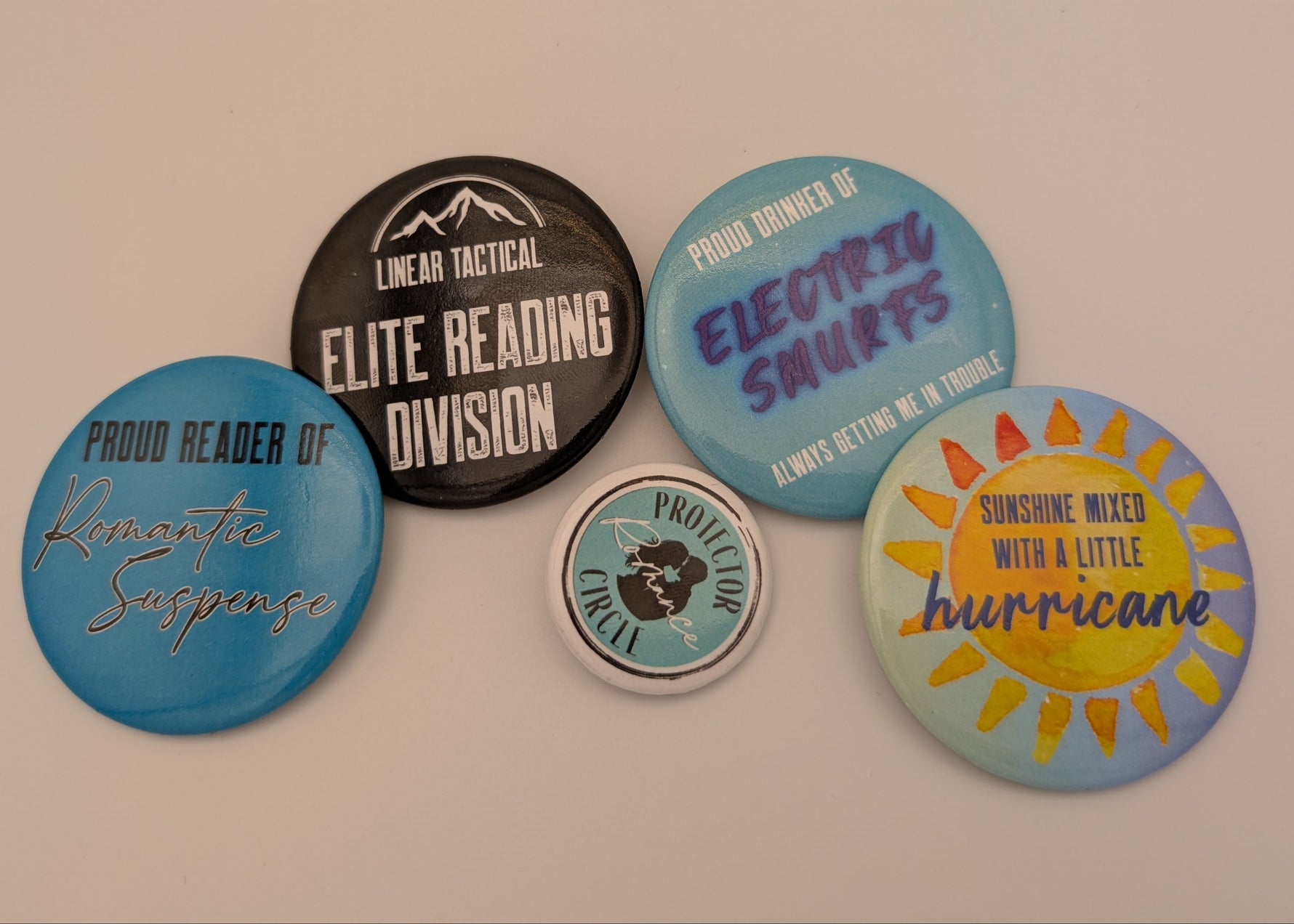 Collection of colorful buttons with various text designs on a beige background